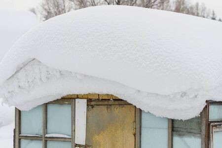Big snow bank on roof of polycarbonate greenhouse in winterの写真素材