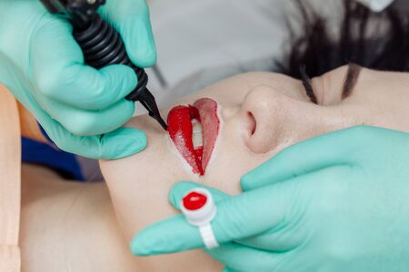 Woman having permanent makeup on lips in beauty salon.の写真素材