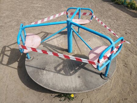 Empy children playground and swing closed for Coronavirus or Covid19. Wrapped in police tape because of quarantineの写真素材