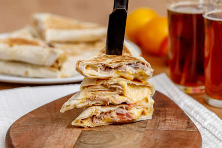 Fastfood shawarma sandwich with tuna fish, tomatoes and cheese. Plunged knife