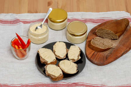 Healthy homemade creamy hummus with vegatables and bread on tableの写真素材
