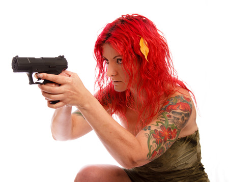 Sexy redhead woman in uniform with gun