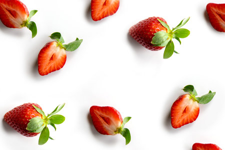 Strawberries on a white background. Pattern of whole berries and halves in random order. Composition in the style of flat lay.の写真素材