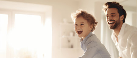 Happy father and son having fun at home, panoramic banner. Active family weekend. Emotional, positive men, passionate about the game. Happy brothers on the blurred background of a bright apartment. The concept of male emotions.の素材