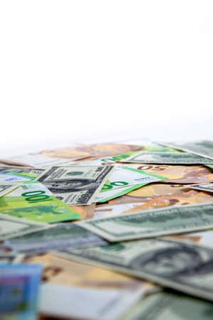 An image of a pile of US dollar and euro banknotes scattered on a white background, with the top of the image being mostly white space.の写真素材