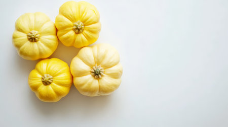 Four lovely pattypan squash stand out on a white background, showing their unique shape.の写真素材