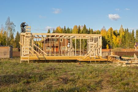 builders install a wooden frame of a houseの写真素材