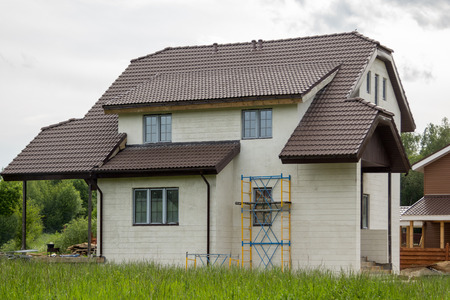 unfinished stone house with scaffolding against the wallのeditorial素材