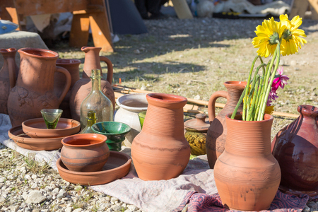 pottery utensils, glass and flowers on the groundの写真素材