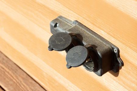 black waterproof outdoor electrical outlet with a rubber capの写真素材