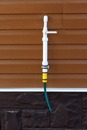 Polypropylene pipe with a tap on a siding wallの写真素材