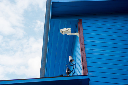 Surveillance camera on the wall of a wooden house