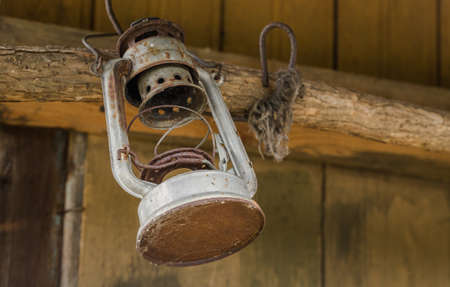 Old oil lamp hanged on wooden wallの写真素材