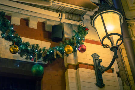 Christmas house outdoor decorations and lantern. Balls and lights on fir.の写真素材