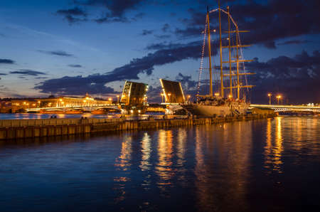 Night cityscape with river and bridge and ship in Saint-Petersburg. Lantern lights on the bridge.の写真素材