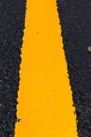 Asphalt road as abstract background, yellow line on the road texture.の写真素材