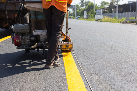 Machine eject and worker on road and traffic sign painting.の写真素材