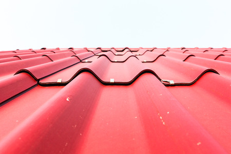 View of red roof tiles and white background.
