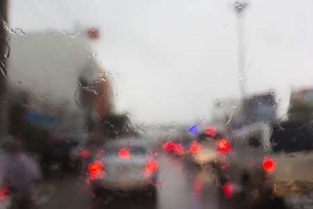 Blurry car silhouette seen through water drops on the car windshield.の写真素材