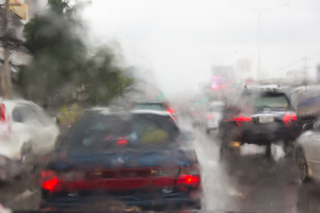 Blurry car silhouette seen through water drops on the car windshield.の写真素材