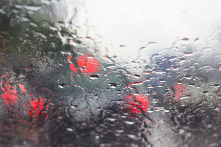 Blurry car silhouette seen through water drops on the car windshield.の写真素材