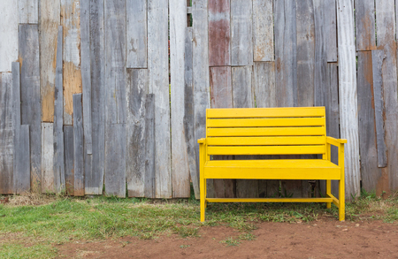 New yellow chair with old wood wall on grass.の写真素材