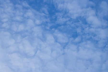 Fluffy white clouds drifting into the blue sky.の写真素材