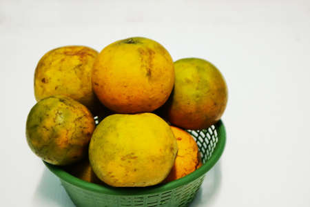Oranges in green basket on a white background.の写真素材