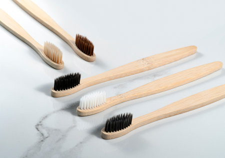 five bamboo toothbrushes on gray background.