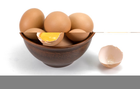 Brown chicken organic eggs in clay bowl. isolated on white background.