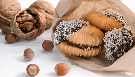 cookies with chocolate and nuts on a white wooden background