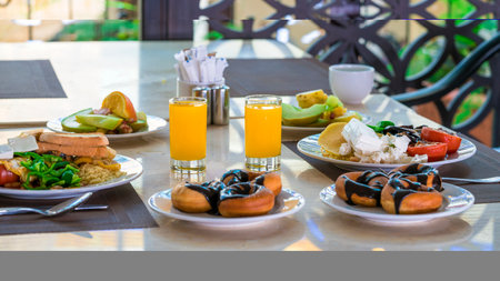 lunch at the restaurant: fruits, chocolate donuts, orange juiceの写真素材