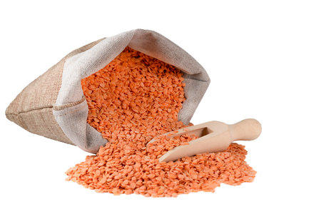 bag of lentils and wooden spoon on white backgroundの写真素材