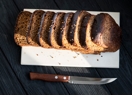 black bread on a wooden board on a black backgroundの写真素材