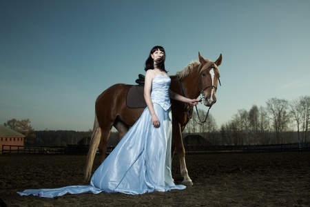 Beautiful young woman with a brown horseの写真素材