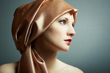 Portrait of the young girl with golden scarf on headの写真素材