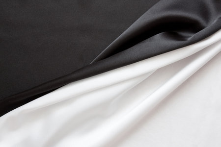 The beautiful silky brilliant black and white wavy fabric halvedの写真素材