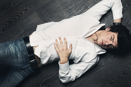 Closeup portrait of the beautiful young sexual man, on a black backgroundの写真素材