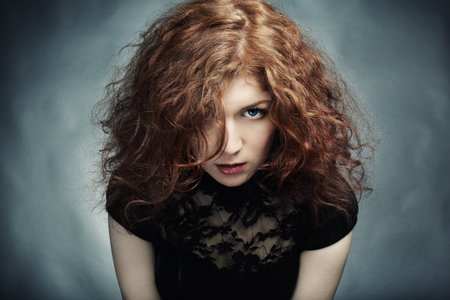 Portrait of the young beautiful woman with curly hair