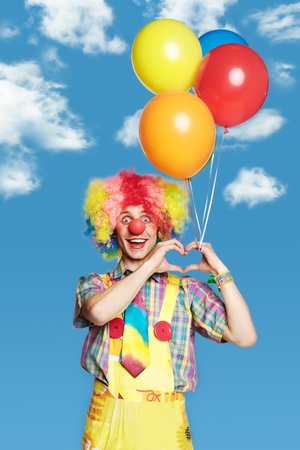 Portrait clown with balloons against the blue skyの写真素材