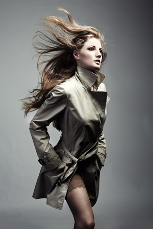 Fashion portrait of young beautiful woman in the raincoatの写真素材