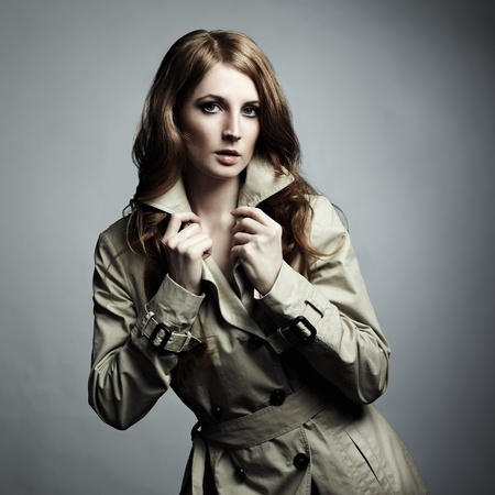 Fashion portrait of young beautiful woman in the raincoatの写真素材