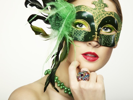 The beautiful young woman in a green mysterious venetian mask の写真素材