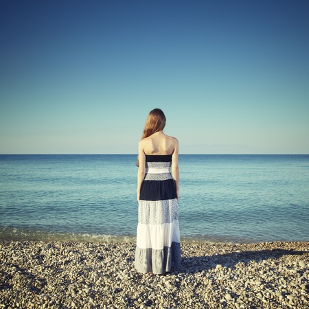 Beautiful young woman standing on the beach. Fashion in Natureの写真素材