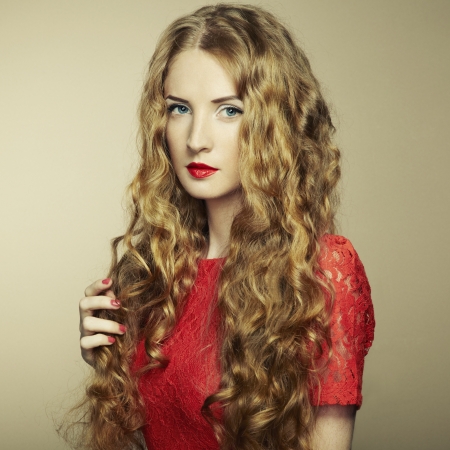 Portrait of beautiful woman with red hair in red dress. の写真素材
