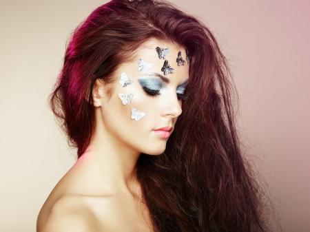 Portrait beautiful young woman with flying hair. Makeup with butterfliesの写真素材