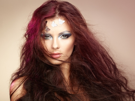 Portrait beautiful young woman with flying hair. Makeup with butterfliesの写真素材