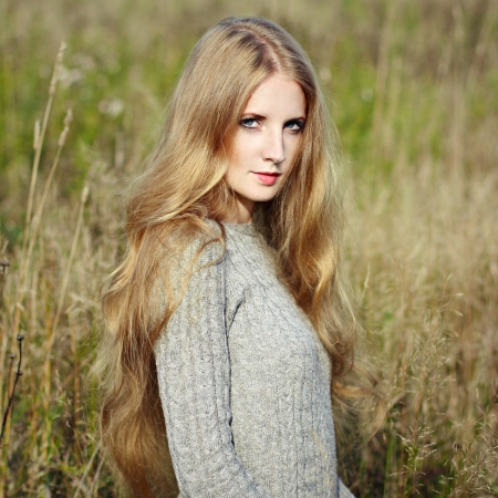 Portrait of beautiful woman on autumn field. Fashion photoの写真素材
