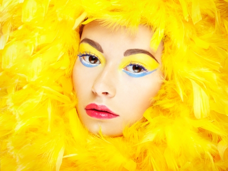 Portrait of beautiful girl in yellow feathersの写真素材