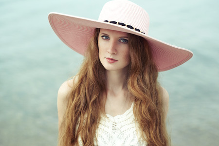 Beautiful woman in hat on the sea. Fashion photoの写真素材